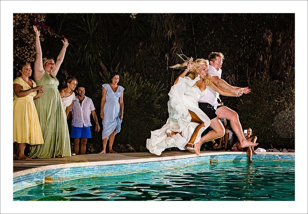 bride and groom jump in the pool