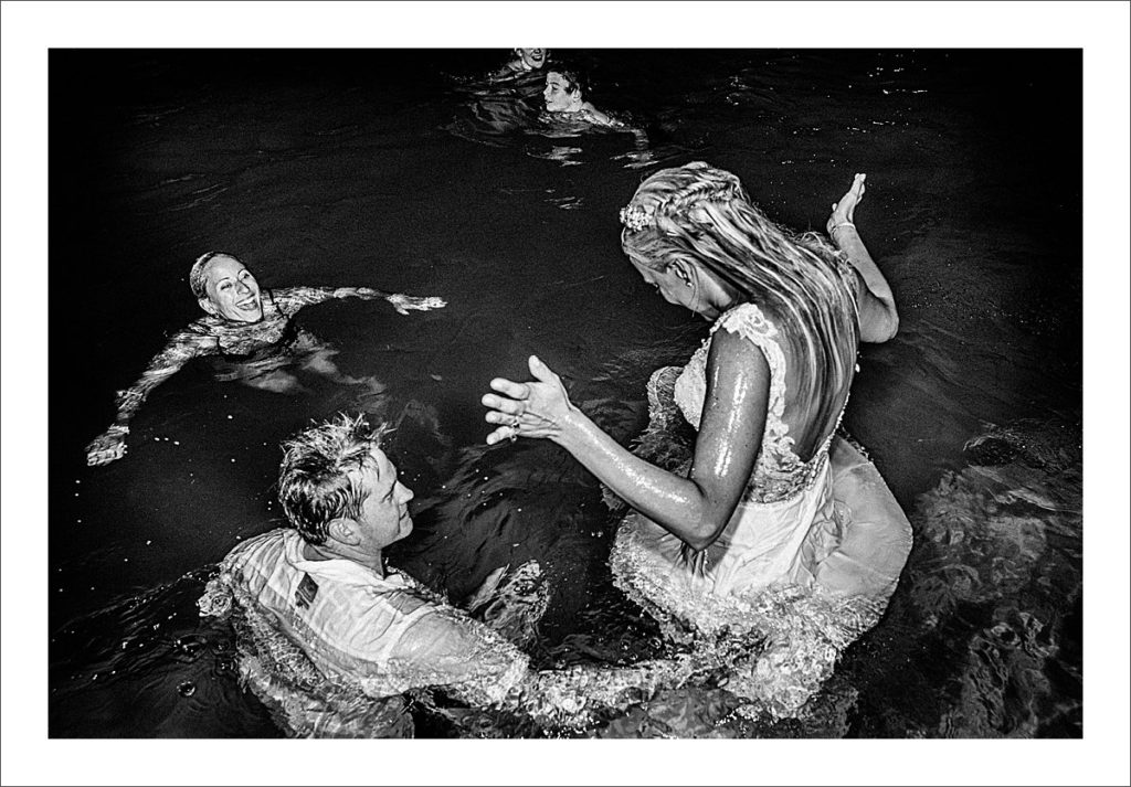 bride and groom jump in the pool